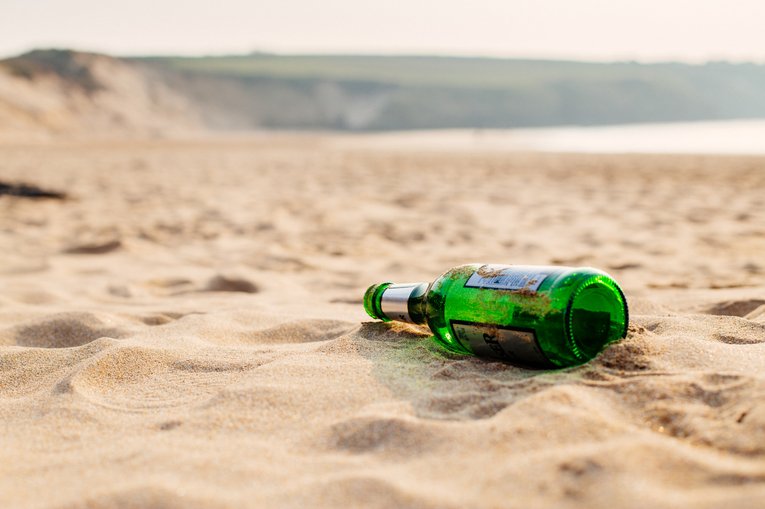 A glass bottle left on the sand