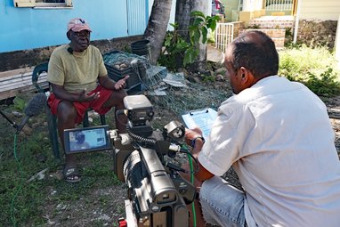 Amdeep interviewing a fisher in Road Town, Tortola for the STEEL Community Voice Method. The camera can be seen.